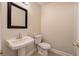 Stylish half bath showcasing a pedestal sink and framed mirror at 863 Fairlong Nw Way, Acworth, GA 30101
