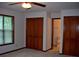 This bedroom features neutral carpet, a ceiling fan and two large closets with paneled doors at 219 Park Avenue, Woodstock, GA 30188