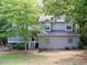 Charming two-story home with gray siding and a welcoming front porch nestled amongst mature trees at 219 Park Avenue, Woodstock, GA 30188
