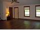 Bright living room featuring hardwood floors, a ceiling fan, and natural light from large windows at 219 Park Avenue, Woodstock, GA 30188