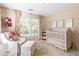 Well-lit Bedroom with a crib, chair, ottoman, and a window that bring in natural light at 4729 Woodland Brook Se Ct, Atlanta, GA 30339