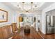 Spacious dining room featuring a modern chandelier, hardwood floors, and access to the living room at 4729 Woodland Brook Se Ct, Atlanta, GA 30339