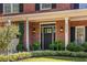 Elegant home entrance with a black front door, brick facade, and manicured landscaping at 4729 Woodland Brook Se Ct, Atlanta, GA 30339