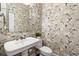 Chic powder room featuring floral wallpaper, a pedestal sink, and a decorative mirror at 4729 Woodland Brook Se Ct, Atlanta, GA 30339