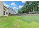 A well-maintained, green backyard bordered by a wooden fence and lush trees at 148 Crystal Downs Way, Suwanee, GA 30024