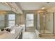 Bathroom with dual sinks, shower, and large mirror with bright lighting at 148 Crystal Downs Way, Suwanee, GA 30024