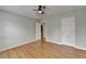 A bedroom has hardwood floors, neutral-colored walls, and two doors at 148 Crystal Downs Way, Suwanee, GA 30024