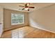 Bright bedroom with hardwood floors, ceiling fan, and a large window offering natural light at 148 Crystal Downs Way, Suwanee, GA 30024