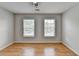Bedroom with hardwood floors, ceiling fan, and natural light from two windows at 148 Crystal Downs Way, Suwanee, GA 30024