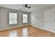 Bedroom with hardwood floors, ceiling fan, and natural light from two windows at 148 Crystal Downs Way, Suwanee, GA 30024