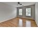 A bedroom boasts hardwood floors and is brightly lit by two windows at 148 Crystal Downs Way, Suwanee, GA 30024