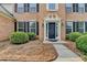 Close-up of the front entrance with a brick facade and manicured shrubs at 148 Crystal Downs Way, Suwanee, GA 30024