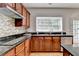 A well-lit kitchen showcases wood cabinets, granite countertops, stainless steel appliances and modern tile backsplash at 148 Crystal Downs Way, Suwanee, GA 30024