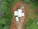 Aerial view of a modern home's roof, nestled in a private, wooded lot with a dirt circular driveway at 5210 Brownlee Rd, Stone Mountain, GA 30087