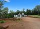 Modern home with flat roof, unique design, and gravel driveway on a sunny day, surrounded by trees at 5210 Brownlee Rd, Stone Mountain, GA 30087