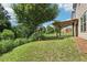 A wooded property line complements the backyard and its covered wooden pergola at 72 Fern Walk, Lawrenceville, GA 30045