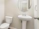 Clean bathroom with pedestal sink, oval mirror, and a toilet in a well-maintained space at 72 Fern Walk, Lawrenceville, GA 30045