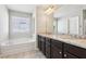 Bathroom featuring a granite countertop, soaking tub, and modern fixtures at 72 Fern Walk, Lawrenceville, GA 30045