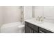 Bathroom with shower/tub combo, white cabinets, and gold hardware at 1659 Tielman Way, Snellville, GA 30078
