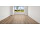 Bright bedroom with hardwood floors and a large window overlooking a green space at 1659 Tielman Way, Snellville, GA 30078