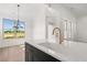 Modern kitchen with white quartz countertops, black cabinetry, and an undermount sink with large windows at 1659 Tielman Way, Snellville, GA 30078