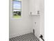 Laundry room featuring graphic tile flooring, white cabinetry, and natural light from a window at 1659 Tielman Way, Snellville, GA 30078