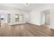 Bright living room with views through multiple windows and glass door, with wood flooring and white walls at 1659 Tielman Way, Snellville, GA 30078
