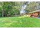 Expansive backyard features lush green lawn, mature trees, and a charming patio area perfect for outdoor entertaining at 1744 Chateau Dr, Dunwoody, GA 30338