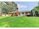 A beautifully maintained backyard showcasing a large lawn, brick patio, and direct access to the home's exterior at 1744 Chateau Dr, Dunwoody, GA 30338