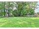 Wide backyard with mature trees, open lawn, and lush landscaping and playground set at 1744 Chateau Dr, Dunwoody, GA 30338