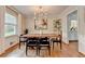 Bright dining room with light fixture, wood table and floors, and shelving unit at 1744 Chateau Dr, Dunwoody, GA 30338