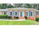 A cozy brick home with blue shutters and door, complemented by a well-maintained lawn and landscaping at 1744 Chateau Dr, Dunwoody, GA 30338