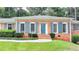 Charming brick home featuring a lush front lawn, and eye-catching blue shutters and door at 1744 Chateau Dr, Dunwoody, GA 30338