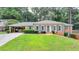 Charming brick home featuring a lush front lawn, a carport, and eye-catching blue shutters and door at 1744 Chateau Dr, Dunwoody, GA 30338
