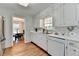Well-lit kitchen with white cabinets, stainless steel appliances, and views to the dining room area at 1744 Chateau Dr, Dunwoody, GA 30338
