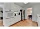 Bright eat-in kitchen features white cabinetry, stainless steel appliances, and beautiful hardwood flooring at 1744 Chateau Dr, Dunwoody, GA 30338