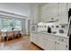 Charming kitchen with white cabinets, tiled backsplash, hardwood floors, and eat-in nook at 1744 Chateau Dr, Dunwoody, GA 30338