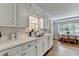 Cozy kitchen with white cabinetry, stainless steel sink, and adjacent breakfast nook with sunlit windows at 1744 Chateau Dr, Dunwoody, GA 30338