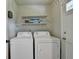 Functional laundry room with white washer and dryer, and storage shelves at 1744 Chateau Dr, Dunwoody, GA 30338