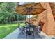 Outdoor patio with seating under a sun umbrella next to a brick house at 1744 Chateau Dr, Dunwoody, GA 30338