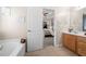 Bathroom view into the primary bedroom suite with a tub and a wooden vanity at 2127 Grant Ave, Mcdonough, GA 30252