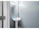 Neutral-toned powder room with a white pedestal sink and classic mirror at 2127 Grant Ave, Mcdonough, GA 30252