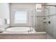 Bright bathroom featuring a soaking tub, tiled shower, and window providing natural light at 355 Glynnwilde Nw Dr, Marietta, GA 30064