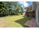 Lush backyard featuring a covered deck, green lawn, and mature trees at 3717 Shady Maple Dr, Stonecrest, GA 30038