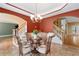 Formal dining room with decorative chandelier, red walls, wood floors and staircase to the side at 3717 Shady Maple Dr, Stonecrest, GA 30038