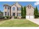 Beautiful two-story brick home featuring a manicured lawn, trimmed shrubbery, and a two-car garage at 3717 Shady Maple Dr, Stonecrest, GA 30038