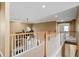 An upstairs loft area with wood railing overlooking the entry, neutral walls and trim and recessed lighting at 3717 Shady Maple Dr, Stonecrest, GA 30038