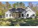 Backyard view of a charming white house with covered patio and mature trees at 728 Harmony Rd, Temple, GA 30179