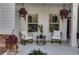 Close up of the inviting front porch with neutral chairs, hanging plants at 728 Harmony Rd, Temple, GA 30179