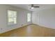 Clean bedroom featuring hardwood floors, paneled closet door, and bright natural lighting at 2808 Peeler Rd, Dunwoody, GA 30360